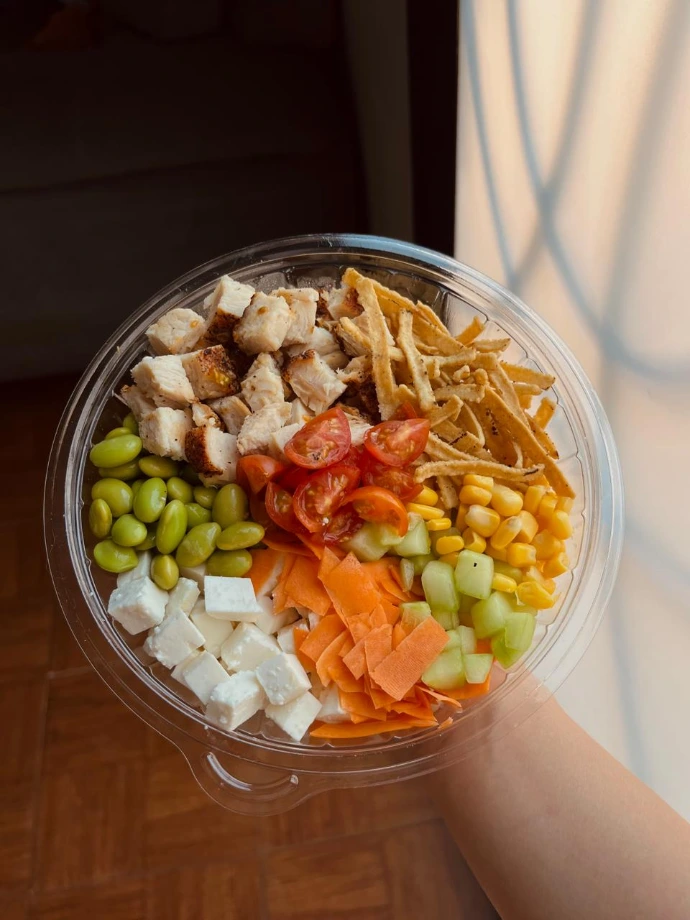 Arma tu bowl a tu medida como este con base de arroz, pollo, edamames, elote, panela, chips, zanahoria y tomates cherrys